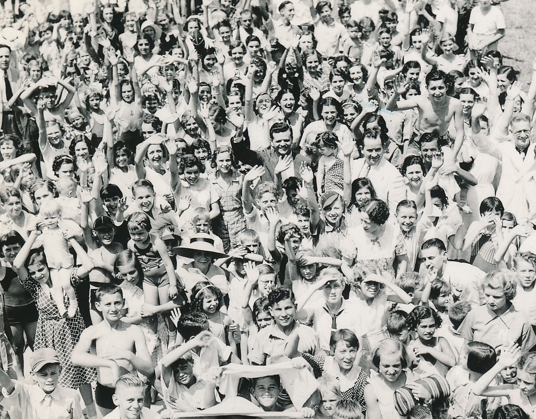 John Zimmerman (center, dark suit, waving), WPA director for recreation projects in Louisiana, celebrates Recreation Day in Algiers, Louisiana with an exuberant crowd. Photo courtesy of the National Archives (ca. 1935-1943).